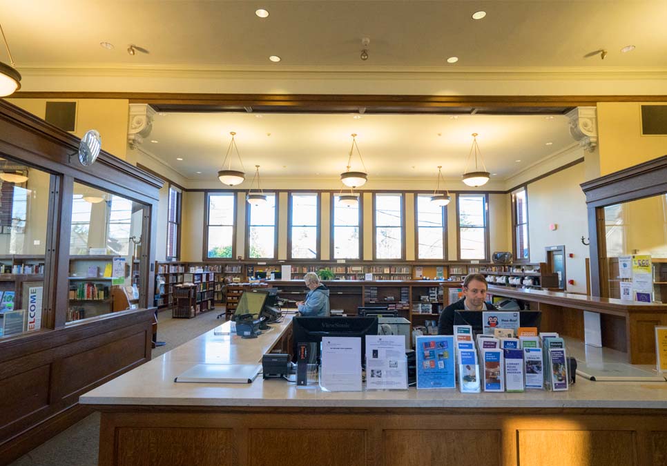 Library staff at service desk area at the West Seattle Branch