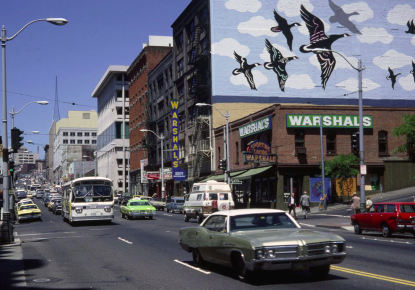 Photo from collection showing a street corner and automobile traffic in Seattle.