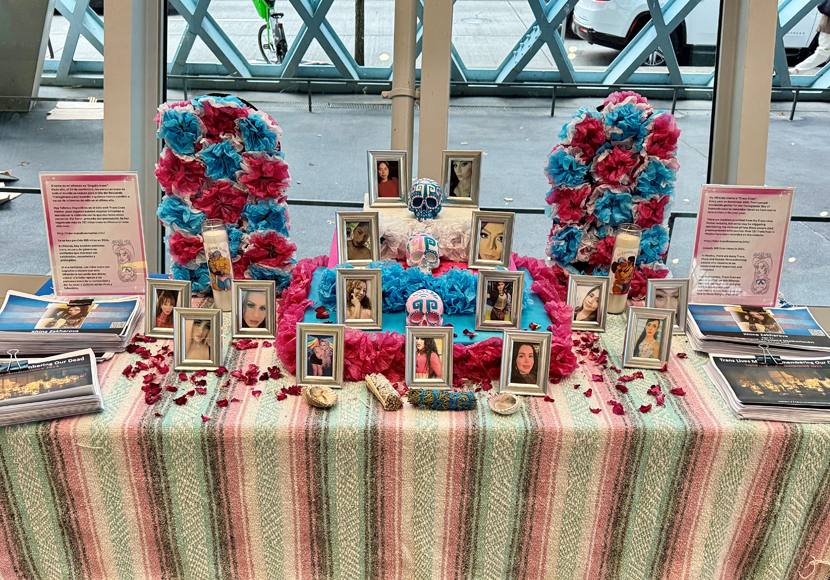 Table with flowers and framed photos of individuals 